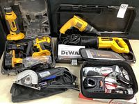 Overall view of five power tools including DeWalt right-angle drill, DeWalt corded drill, DeWalt reciprocating saw, Dremel Ultra-Saw, Craftsman Nextec driver
