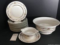 Stack of twelve 9-inch salad plates, sauce boat with attached underplate, and large serving bowl, all with matching floral and ribbon pattern