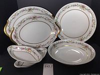 Photo showing all six pieces of the set including platters, bowl, and relish dishes with floral gold trimmed pattern