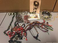 Overview photo showing assorted jewelry including multiple bracelets, necklaces, and the mink trimmed pin.