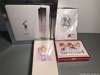 Four boxes of Christmas cards including one with reindeer 'NOEL' design, one with angel illustration, a Hallmark box with cherub ornament on top, and a box showing angel children playing instruments