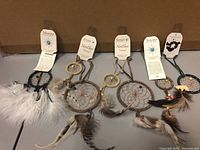 Full view of seven dream catchers arranged side by side with tags visible