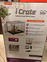 Box front showing iCrate dog crate two door folding crate features including home training system, divider panel, foldable design, and safe secure latches.
