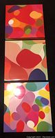 Three square colorful abstract prints stacked vertically, each approx. 35cm x 35cm