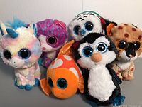 Photo shows set of six TY Beanie Boos plush toys without tags including unicorn, cat, fish, penguin, leopard, owl.