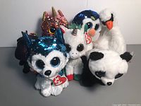 Seven TY Beanie Boos Plush Toys with Tags including two unicorns, a swan, panda, penguin, and sequined husky or wolf and dragon