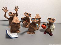 Front view of all six E.T. figures displaying various poses and accessories.