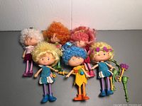 Photo of six vintage Herself The Elf dolls arranged in two rows with various hair colors and accessories.