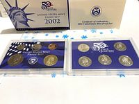 Photo shows two plastic-encased sets: the 2002 US Mint proof set with five standard coins and the 52 State Quarters set with five state quarters, next to the box and Certificate of Authenticity.