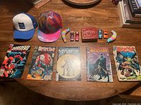 Lot items including hats, comic books, toy cars, party horns, playing cards, and poker chips arranged on table
