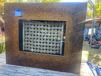 Photo showing full view of the framed art piece displayed outdoors with natural lighting.