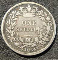 Obverse side of the 1834 British silver one shilling coin showing the crowned denomination and date with wreath