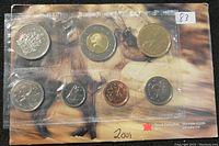 Front view of sealed 2001 Canadian uncirculated coin set showing all 8 coin denominations in original Royal Canadian Mint packaging with artistic background.
