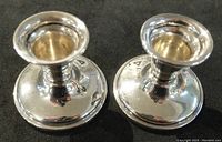Top view of the two sterling silver candle holders on black surface.