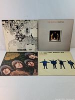 Four Beatles vinyl records displayed with front covers visible