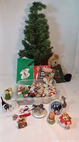 Full view of Christmas tree, books, various ornaments including plush teddy bear and elf figurine