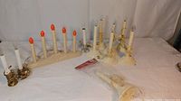 Full lot view showing multiple vintage electric candles and candelabras on white backdrop.