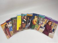 Top down view of all 7 paperback American Girl Doll books fanned out showing covers.