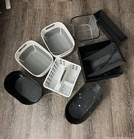 Photo of 9 assorted baskets and bins displayed on wood floor, showing the variety of plastic and metal items.