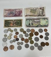 Overview of the lot showing 4 banknotes and multiple coins of different types and origins.