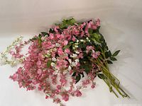Pink and white hanging flower picks with green leaves laid out together