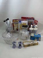 Photo of assorted new kitchen items including clear bowls, glass spice grinders, condiment bottles, and cocktail accessories.