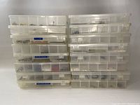 Front view of stacked plastic storage containers filled with various beads and findings.