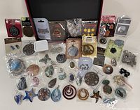 Overhead photo showing the complete lot of new jewelry making components arranged on a flat surface, including various shapes, materials and packaging