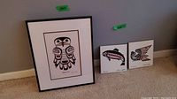 Wide view showing all three pieces: framed Hiada Owl print and two smaller decorative tiles.