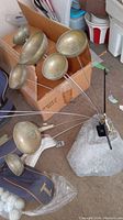 Woodstock Garden Bells metal brass-colored bells on rods attached to a rock base, showing the array of bells.