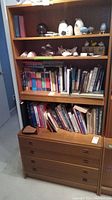 Front view of assembled two-piece shelf unit loaded with books and decorative items
