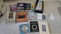 Overview of lot items including books, tarot cards, fabric pouch with stones, statue and candles.
