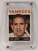 Front view of 1964 Topps Yogi Berra baseball card inside clear screw down display case showing card intact and well preserved.