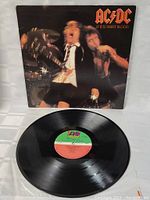 Front of vinyl record with live performance image on album cover and visible center label on record.