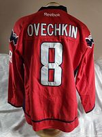 Back of the red hockey jersey showing OVECHKIN name and number 8 with Reebok branding on collar.