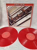 Two red vinyl records with red Capitol label placed in front of the gatefold cover