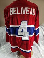 Back view of the red Jean Beliveau Montreal Canadiens hockey jersey showing name and number 4 details