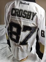 Back view showing 'Crosby' name and number '87' with black and gold trim on white jersey fabric.