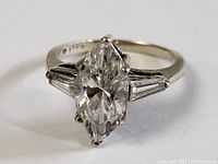 Front angled view of vintage sterling silver ring with marquise-cut center stone and baguette side stones.