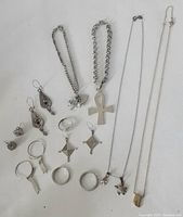 Full set of 18 assorted sterling silver jewelry pieces showing bracelets, necklaces, rings, and earrings on a white surface.