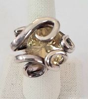 Front angle of antique fork ring showing yellow citrine stone and silver-tone fork tines wrapped around the stone.