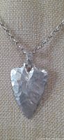 Front view of hammered sterling silver arrowhead pendant necklace showing texture and shape.