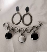 Photo showing sterling silver and onyx hoop earrings and Ben Amun bracelet with three round charms