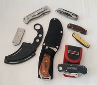 Overview showing seven different cutters and knives including folding knives and fixed blade with sheath