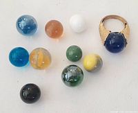 Photo showing the vintage gold-tone ring with blue orb and ten additional colorful interchangeable orbs arranged on a white background.