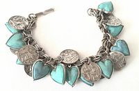 Photo showing the full bracelet laid flat with clear view of the alternating turquoise hearts and round coin charms.