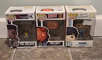 Three boxed Funko Pop figures displayed side by side: Hellboy 750 in center, Del Walker 116 on left, Pedro 205 on right.