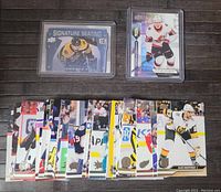 Photo showing Charlie Coyle Signature Seating autograph card, Upper Deck Premier rookie card of Lassi Thomson, and multiple assorted hockey cards spread out in bottom showing various players.