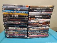 Photo showing two stacks of DVD movie cases with visible titles including The Walk, Spinning Into Butter, Fist To Fist, How to Deal, Stone, The Night Listener, Linn, Animal Kingdom, Be Cool, King Kong, Moscow Zero, What's Eating Gilbert Grape, Bruce Lee Martial Arts Masters, 16 Blocks, Silent Kings.