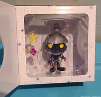 Figure in plastic display window inside branded box showing character and accessories.